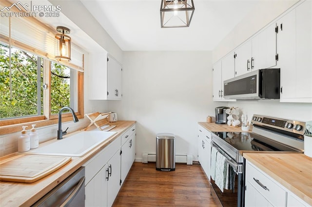 kitchen with white cabinetry, appliances with stainless steel finishes, sink, and pendant lighting