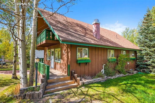 back of property featuring a yard and a deck