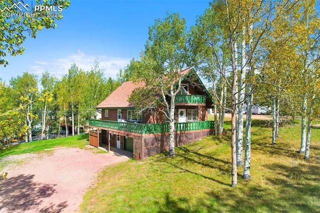 view of front of property featuring a wooden deck and a front lawn