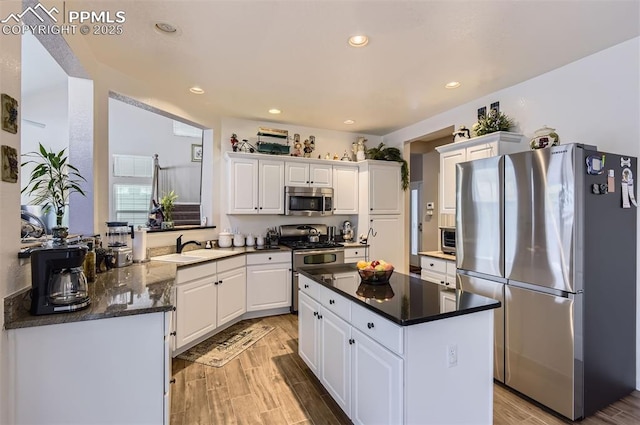 kitchen featuring dark stone countertops, white cabinetry, sink, and appliances with stainless steel finishes