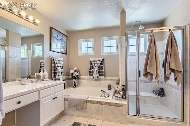 bathroom with independent shower and bath, a textured ceiling, tile patterned floors, and a healthy amount of sunlight