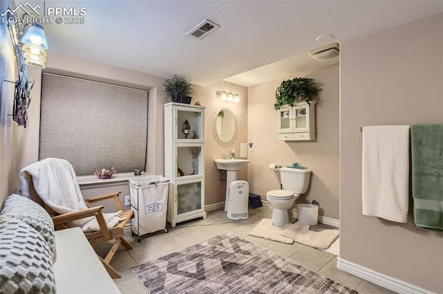 bathroom with toilet and tile patterned floors