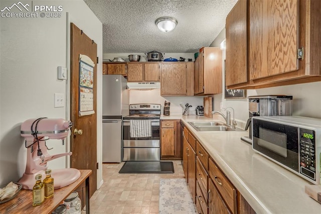 kitchen featuring a textured ceiling, sink, and appliances with stainless steel finishes