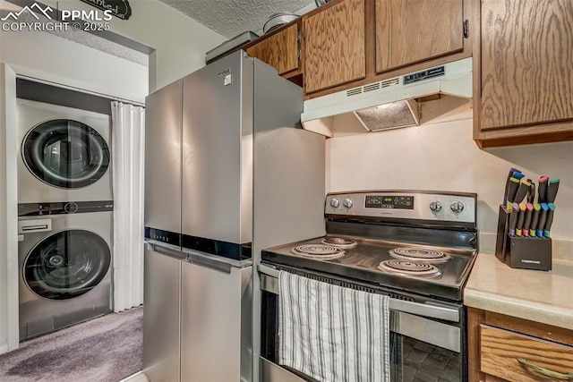 kitchen featuring carpet flooring, stacked washing maching and dryer, stainless steel range with electric cooktop, and a textured ceiling