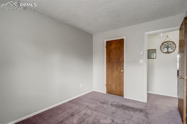 carpeted empty room featuring a textured ceiling