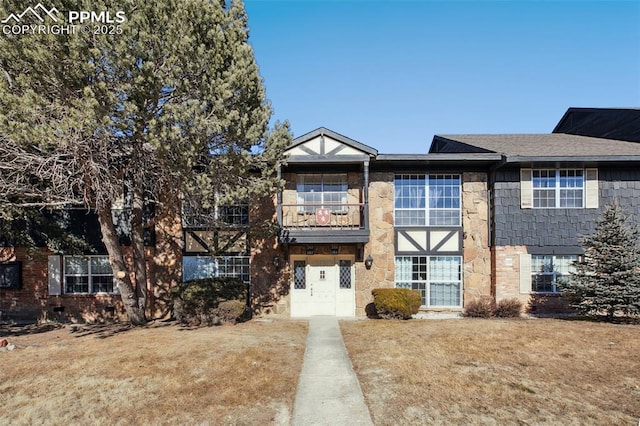 view of front of house with a front yard and a balcony