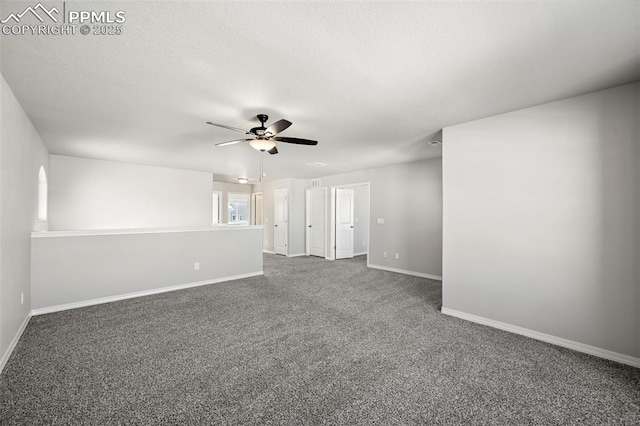 empty room with dark colored carpet and ceiling fan