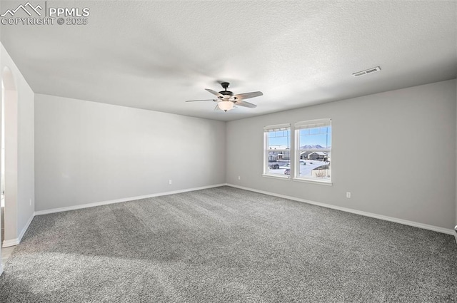 carpeted spare room featuring ceiling fan and a textured ceiling