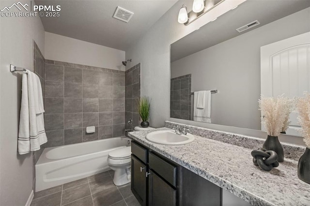 full bathroom with tile patterned floors, tiled shower / bath combo, toilet, and vanity