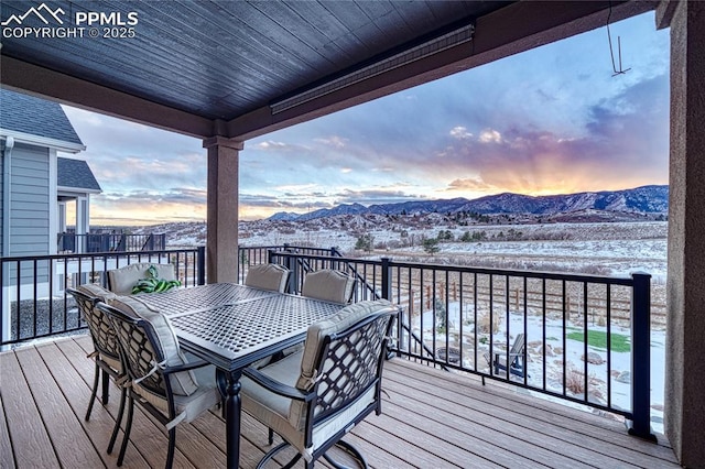 snow covered deck with a mountain view