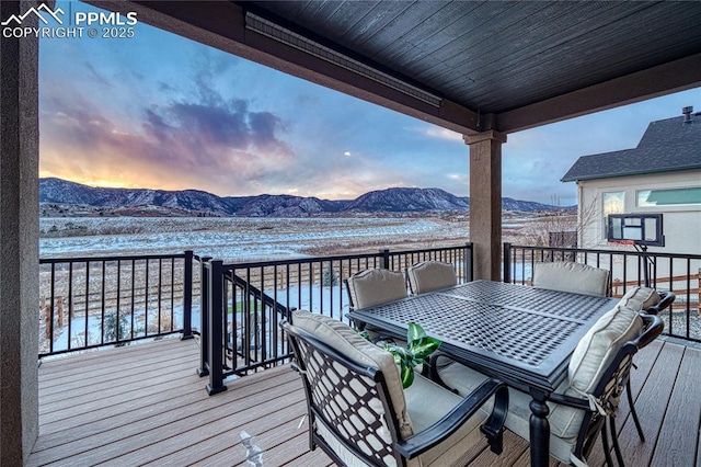 snow covered deck with a mountain view