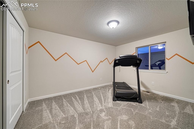 exercise area with carpet flooring and a textured ceiling