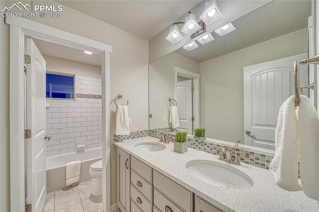 full bathroom featuring vanity, tiled shower / bath, tile patterned flooring, toilet, and a textured ceiling