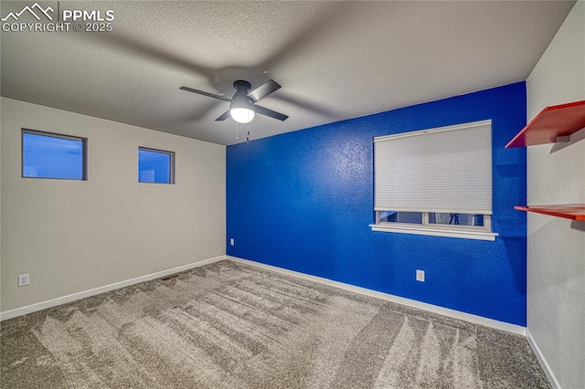 carpeted spare room with a textured ceiling and ceiling fan