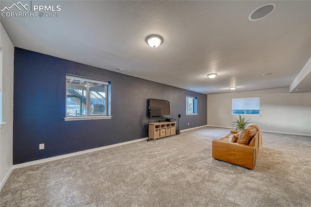 sitting room with carpet, a textured ceiling, and a healthy amount of sunlight