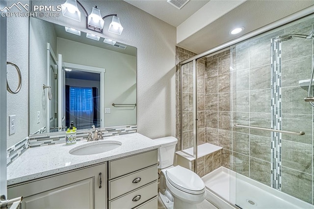 bathroom featuring vanity, toilet, and an enclosed shower