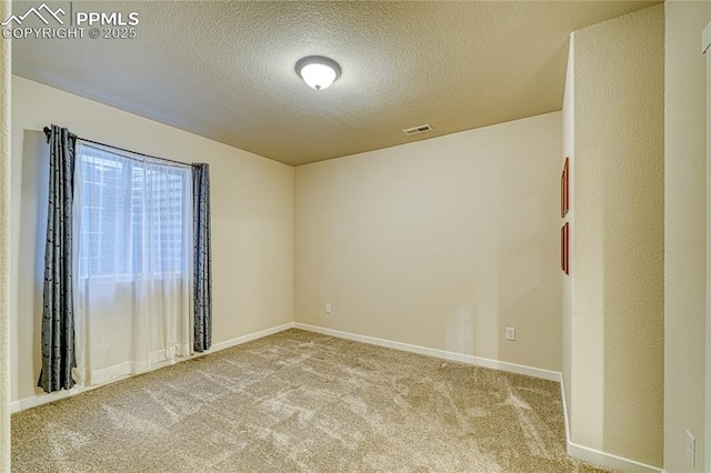 carpeted empty room with a textured ceiling