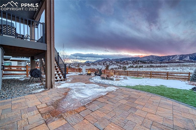 snow covered patio with a mountain view