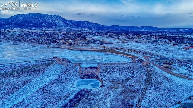 snowy aerial view with a mountain view