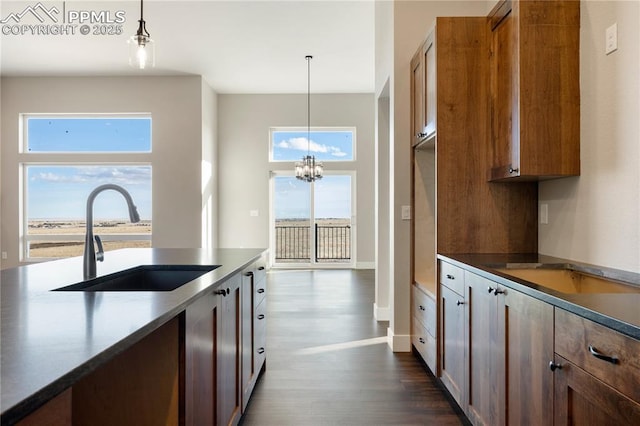 kitchen featuring a notable chandelier, pendant lighting, dark hardwood / wood-style flooring, and sink