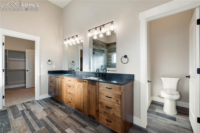 bathroom with toilet, vanity, hardwood / wood-style floors, and tiled shower