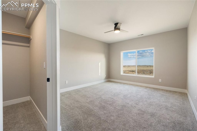 unfurnished bedroom with carpet floors, ceiling fan, and a spacious closet