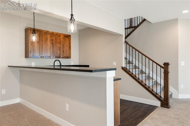 kitchen with pendant lighting, kitchen peninsula, and dark carpet