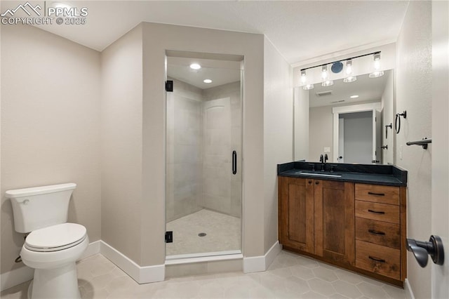 bathroom with walk in shower, vanity, tile patterned floors, and toilet