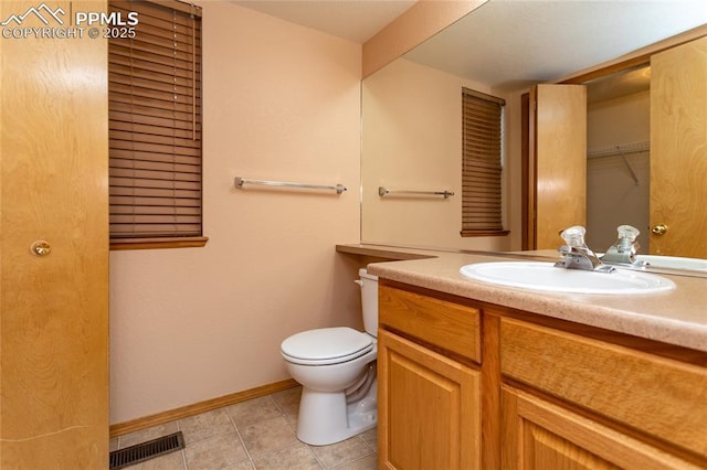 bathroom with toilet, tile patterned floors, and vanity