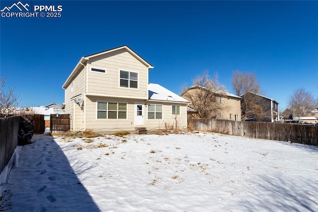 view of snow covered rear of property