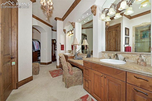 bathroom with a notable chandelier, vanity, a shower with door, and crown molding