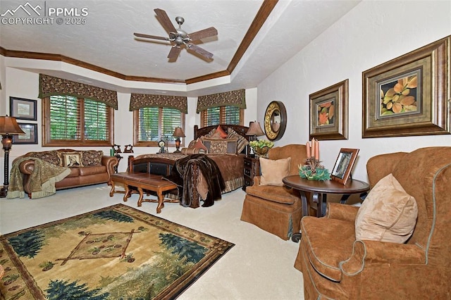 carpeted bedroom with a tray ceiling, ceiling fan, a textured ceiling, and ornamental molding