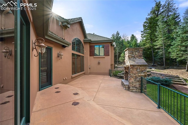 view of patio with an outdoor stone fireplace