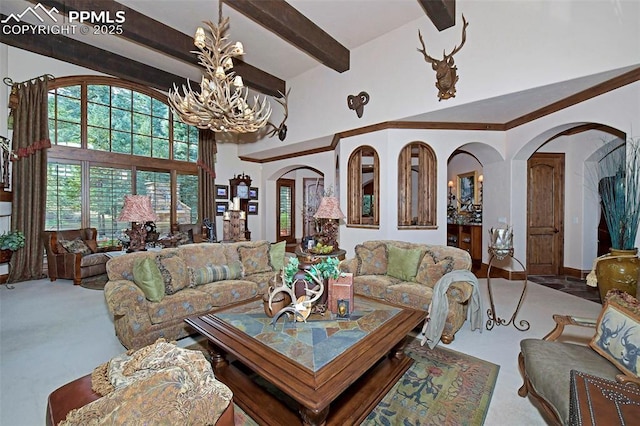 carpeted living room featuring a high ceiling and an inviting chandelier