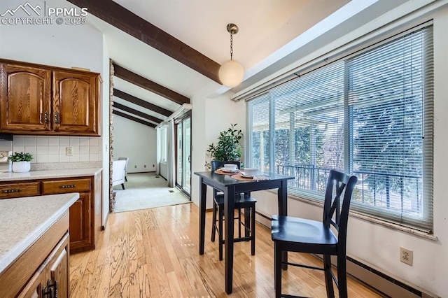 dining space featuring vaulted ceiling with beams, baseboard heating, and light hardwood / wood-style flooring