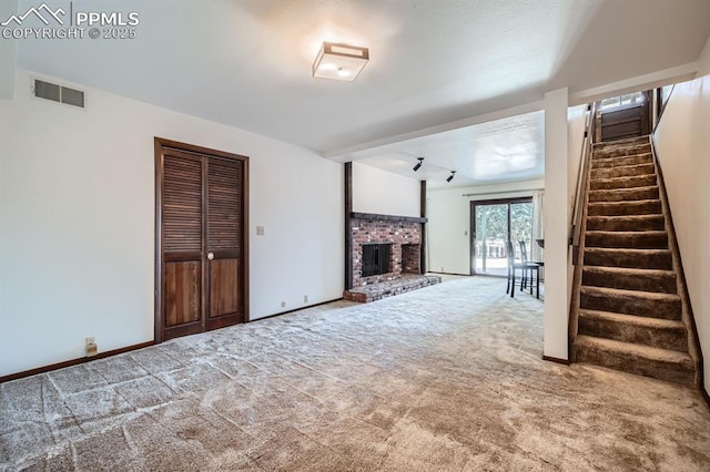 unfurnished living room featuring carpet flooring and a brick fireplace