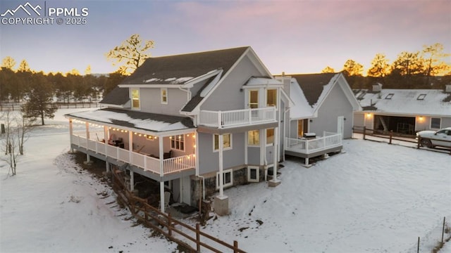 snow covered property with a balcony