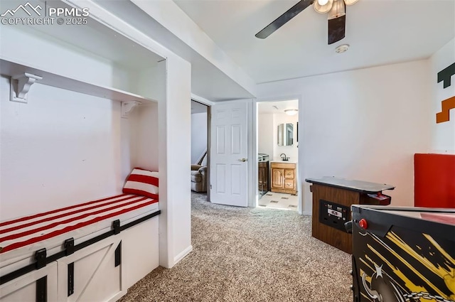 carpeted bedroom with ceiling fan, ensuite bathroom, and sink