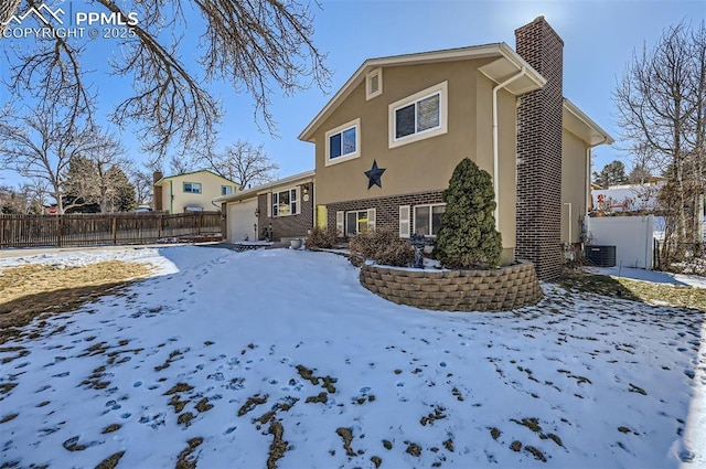 snow covered property with central air condition unit