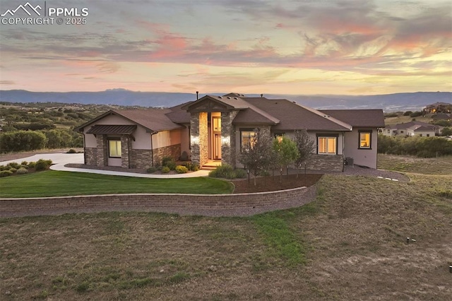 view of front facade with a mountain view and a yard