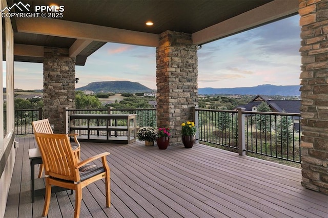 deck at dusk featuring a mountain view