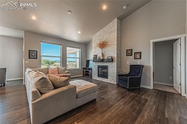 living room featuring a fireplace, dark hardwood / wood-style flooring, and high vaulted ceiling