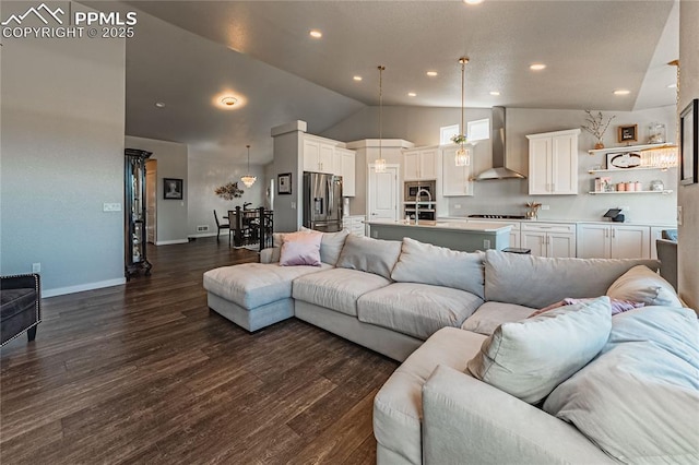 living room featuring sink, dark wood-type flooring, and high vaulted ceiling