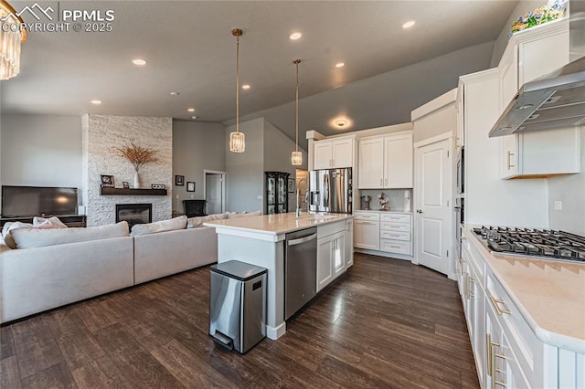 kitchen featuring a center island with sink, wall chimney exhaust hood, white cabinets, and appliances with stainless steel finishes