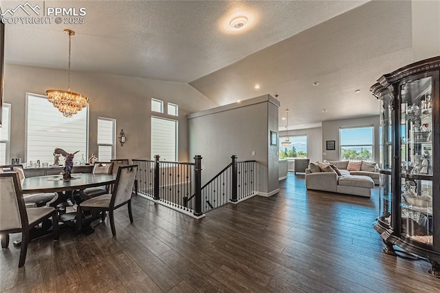 dining space with a chandelier, a textured ceiling, dark hardwood / wood-style floors, and lofted ceiling