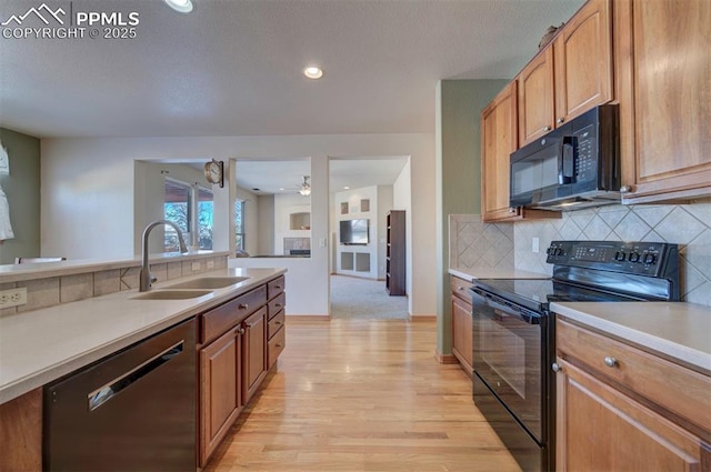 kitchen featuring ceiling fan, sink, light hardwood / wood-style flooring, backsplash, and black appliances