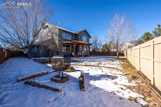 snow covered house featuring a fire pit