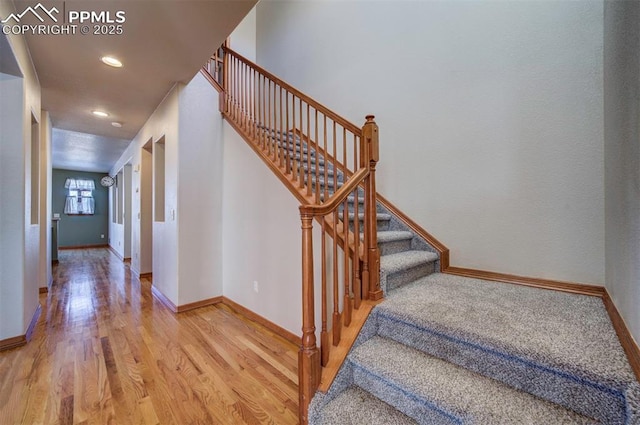 staircase with hardwood / wood-style flooring