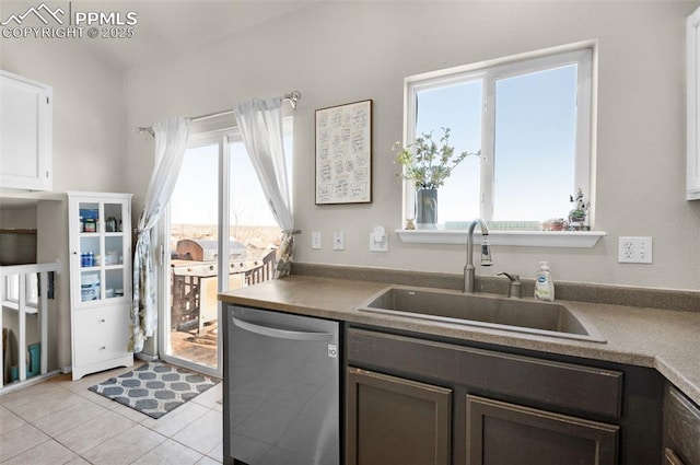 kitchen featuring stainless steel dishwasher, white cabinets, sink, and a wealth of natural light