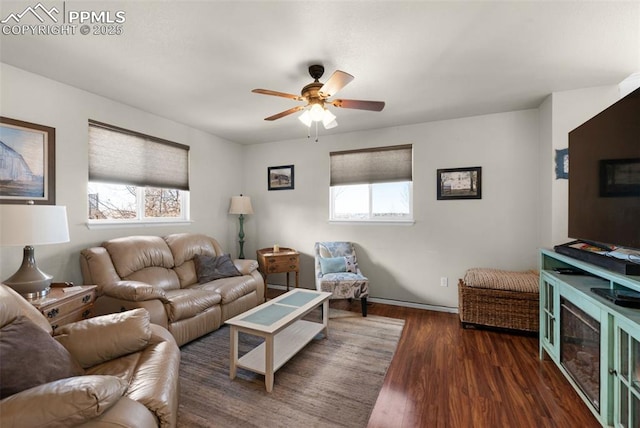 living room with ceiling fan and dark wood-type flooring